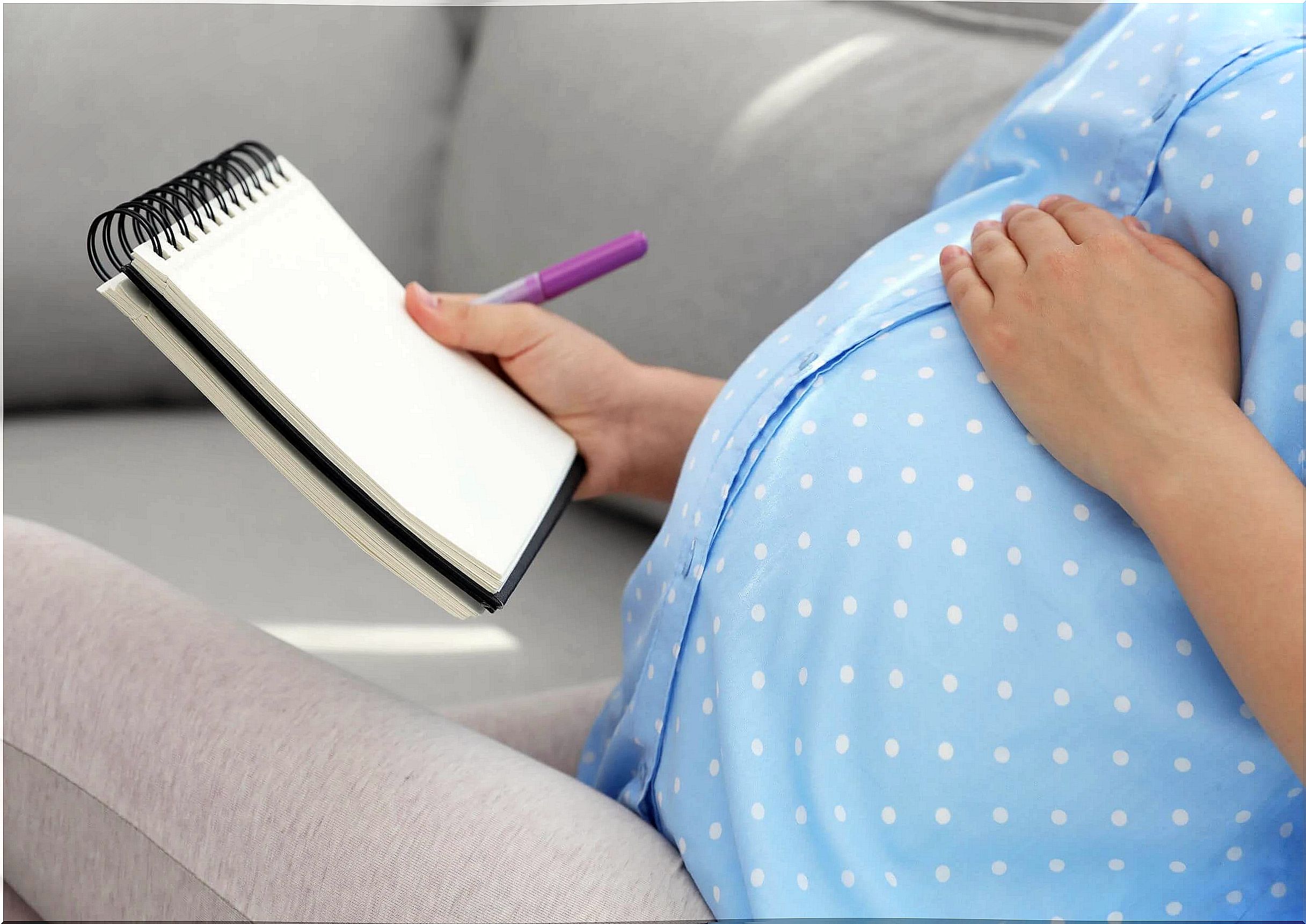 Pregnant woman thinking and writing the names of elf babies.