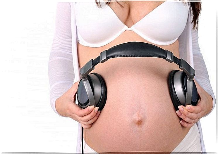 pregnant woman with earphone on her belly