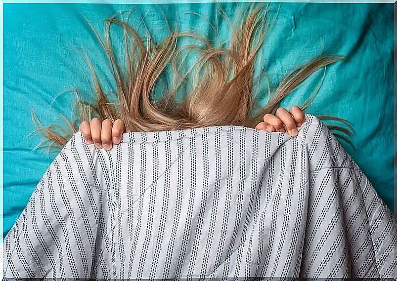 Girl covered with the sheet because she is afraid of having nightmares.