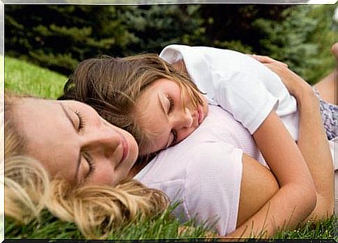 mother lying on the grass with daughter